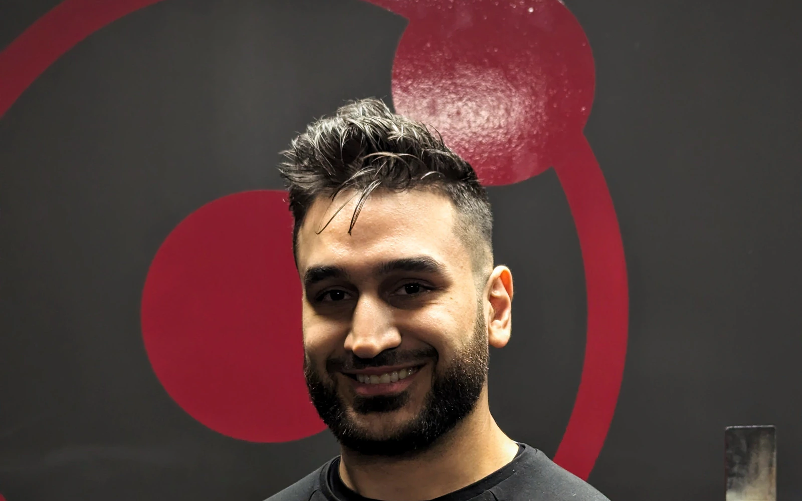 Youssef, coach at Retraine in Pickering, by the studio logo wall.