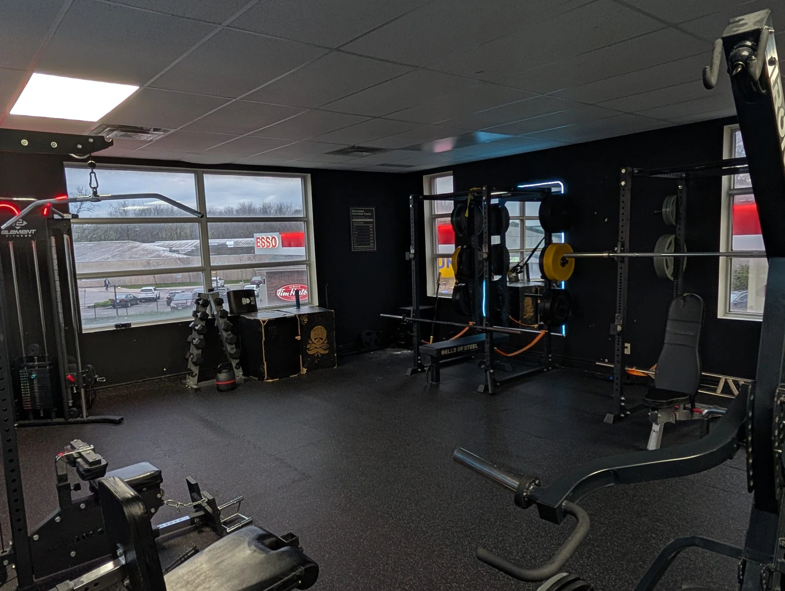 Bright squat-rack floor at Retraine in Pickering by the windows, where recovery and mobility work happen between sessions.