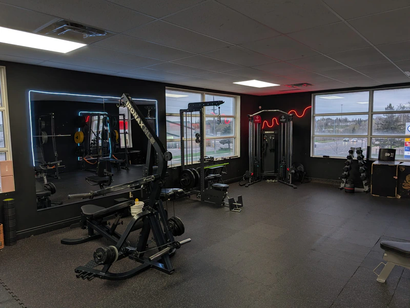 Wide view of the mirror room at Retraine with red neon and dual window light.