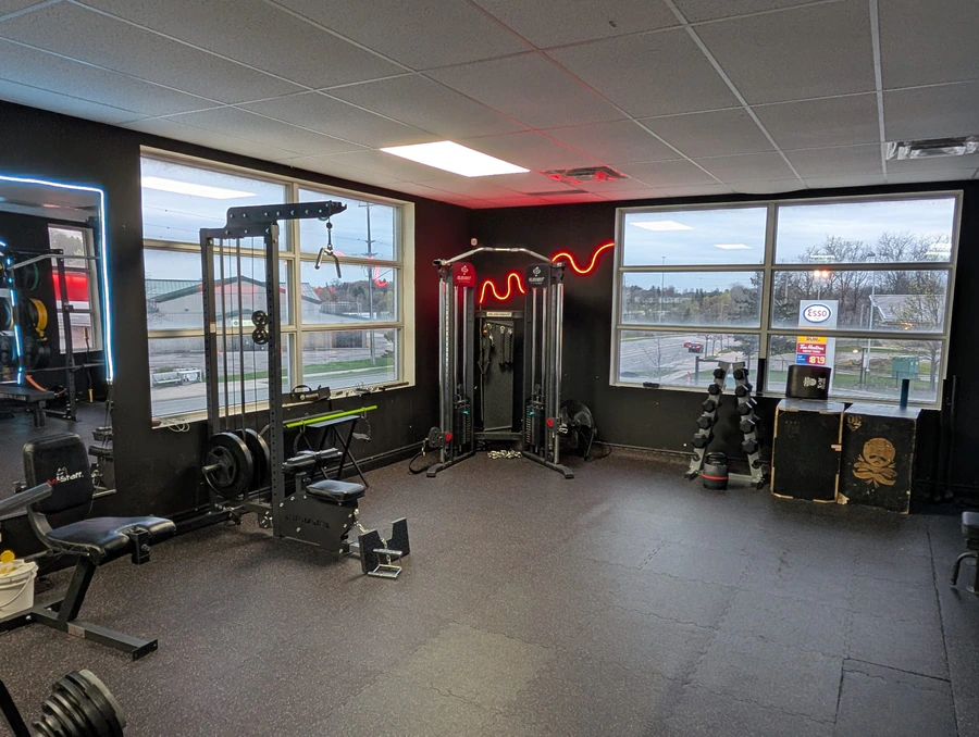 Functional trainer and cable machine in the corner of Retraine with two large windows.